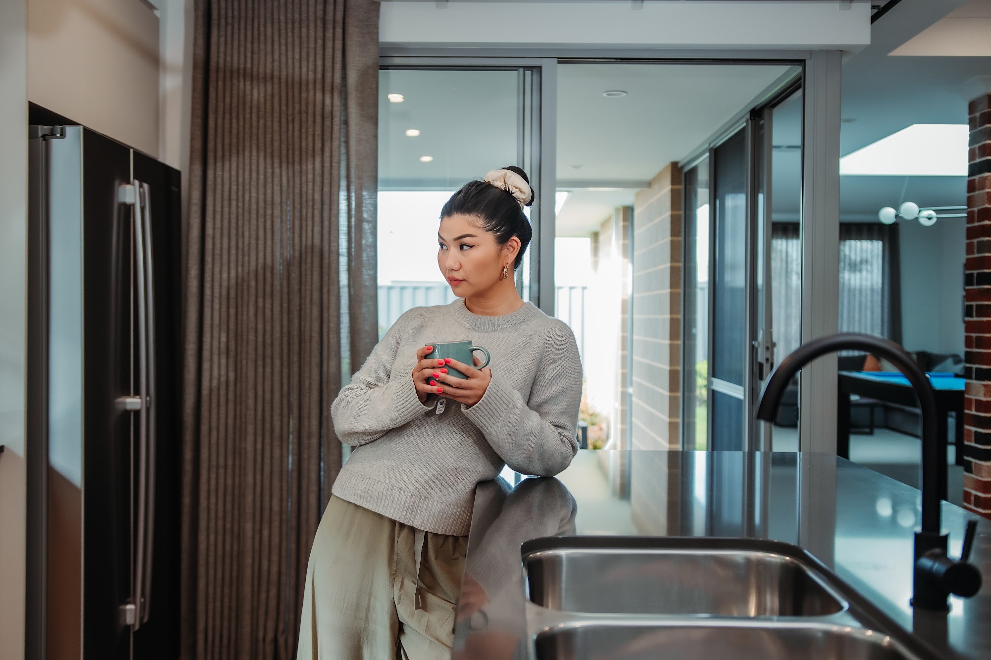 Homeowner with a coffee by the window of her new home